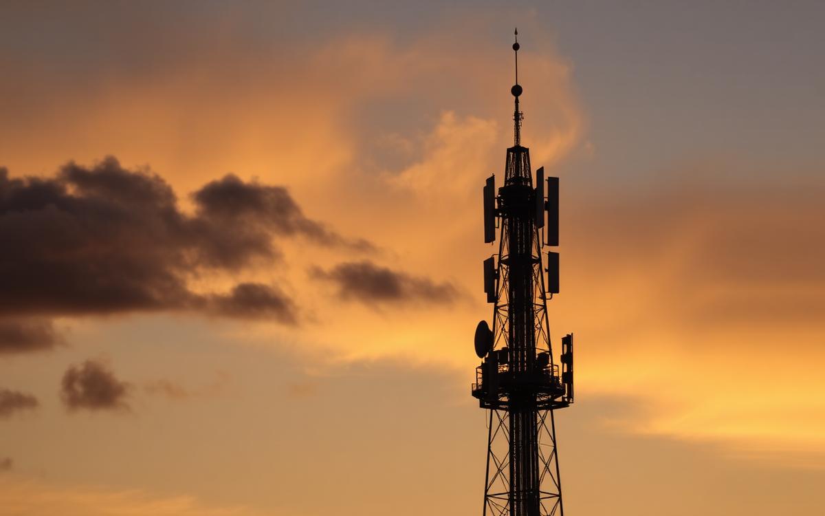 Broadcast tower silhouetted against a golden dusk sky